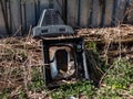 View of old tv broken into pieces thrown out in nature near a fence. Discarded electronics Royalty Free Stock Photo