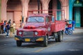 view of old vintage retro classic straight truck standing on Cuban Havana street with people in background