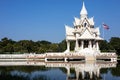 A view of an old white concrete pagoda in Thai style installed amid a large pond Royalty Free Stock Photo