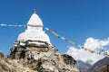 Old white stupa and prayer flags near Pangboche with Ama Dablam in the background Everest Base Camp trek Nepal