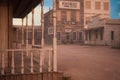 View from an old wooden house across a dusty street in an old town in the American wild west. 3D rendering Royalty Free Stock Photo