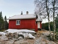 View of an old wooden red house in the middle of a forest in Siljan, Norway during winter Royalty Free Stock Photo
