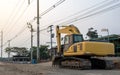 View of an old yellow backhoe parked on the road being renovated