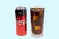 View of open coca can and soda with ice in crystal glass. Drink concept.