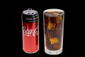 View of open coca can and soda with ice in crystal glass isolated on black background. Drink concept.