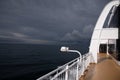 A view of the open, deep blue sea from the railing of a passenger ship - in the background you can see how a storm Royalty Free Stock Photo