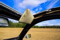 View through open folding roof and windows of classic French cabriolet car 2cv beyond a-pillar, rearview mirror and sun shield on Royalty Free Stock Photo