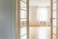 View through open glass door on an empty, bright bedroom interior with big windows, white walls and herringbone floor Royalty Free Stock Photo