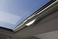 View through open sunroof of blue sky