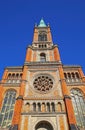 View on orange color church facade from 18th century in romanesque revival style against blue sky