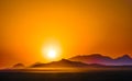 Orange sunset over the mountains in the desert Royalty Free Stock Photo