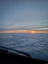 A View Out A Plane Window Looking At The Clouds At Sunset