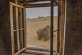 View out of a window at German Kolmanskop Ghost Town with the abandoned buildings in the Namib desert