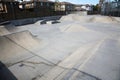 View of outdoor empty concrete skate park with ramps and pipes in California. Skate Parks are a great place for kids to do tricks