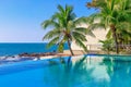 View of the outdoor pool by the sea. There is a lush palm tree next to the pool. Sanya, China. Royalty Free Stock Photo