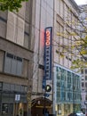 View of the outdoor, vertical neon sign for AMC movie theater in downtown Seattle on an overcast