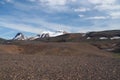 View over barren dry brown hilly rough terrain on snow capped mountains - Iceland