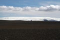 View over black wide endless black barren wasteland with snow capped mountains - Iceland