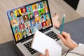 View over businesslady shoulder seated at workplace desk look at computer screen where collage of many diverse people Royalty Free Stock Photo