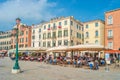 View over busy with tourists crowds Venice, piers, outdoor restaurants, promenade embankment near Doge Palace and Campanile in