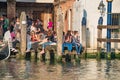 View over busy with tourists crowds Venice, piers, promenade embankment where people relax near Doge Palace and Campanile in