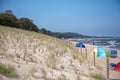 The view over the dune to the beach with many tents and beach chairs from Zempin on the island Usedom