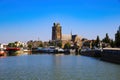 View over dutch inland harbor on skyline of old town with church tower against blue summer sky