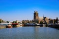 View over dutch inland harbor on skyline of old town with church tower against blue summer sky