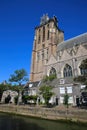 View over dutch water canal on residential houses with gothic church background against blue summer sky - Dordrecht, Netherlands Royalty Free Stock Photo