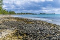 A view over an eroded rocky headland towards a distant resort on the island of Eleuthera, Bahamas