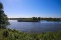 View over green rural landscape on river Maas with inland waterway vessel against blue summer sky - Between Roermond and Venlo,