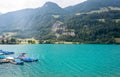 View over the Lake Lungern. Lungernsee is a natural lake in Obwalden. Wooden pier with boats. Beautiful lake with