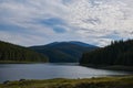 A view over the Lake Oasa in Mountains Sureanu with sky with clouds and forest Royalty Free Stock Photo