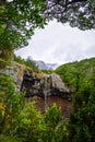 View over Mangawhero Falls rushing down from 20m height of the rocks into a small river. Magnificent peaks of Mt Ruapehu