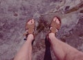 View over own legs to the word. Sandstone rock above valley