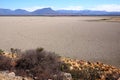 View over parched and empty dam, with cracked mud Royalty Free Stock Photo