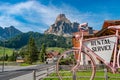 View over a pin city bicycle with banner rental service at magical Dolomite peaks, forests and hotels at sunny day and blue sky,