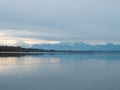 Greifensee, Switzerland - April 7th 2023: Plain water surface of lake Greifensee with the Alps Royalty Free Stock Photo