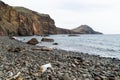 Landscape view over a mountains and plastic pollution on a pebble beach, Madeira island, Portugal Royalty Free Stock Photo