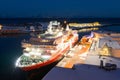 View over the port of Svolvaer on the Lofoten islands with cruise ship and wooden racks for drying cod fish at night Royalty Free Stock Photo