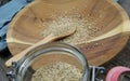 View over preserving jar with red rubber ring on isolated raw sesame seeds on spoon and wooden plate Royalty Free Stock Photo