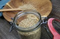 View over preserving jar with red rubber ring on isolated raw sesame seeds on spoon and wooden plate Royalty Free Stock Photo