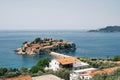 View over the red roofs of old houses to the isthmus to the island of Sveti Stefan. Montenegro