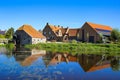 View over reflecting river pond on old water mill restaurant against deep blue cloudless summer sky - Neer Limburg, Netherlands Royalty Free Stock Photo