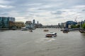 Lots of boats on River Thames London, HMS Belfast on left and a river cruise boat center frame