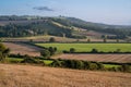 View over rolling english countryside at sunset in summer under blue sky with one cloud Royalty Free Stock Photo