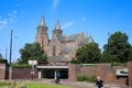 View over roundabout on gothic church towers of St. Walburgiskerk against blue summer sky