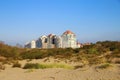 View over sand dunes with grass on coast town against clear blue summer sky - Knokke-Heist, Belgium Royalty Free Stock Photo