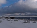 View over Schliffkopf , Germany in Black Forest with hotel building and snow-covered meadow with frozen trees in deep snow.