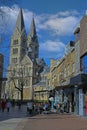 View over shopping street with cafe on medieval church tower against blue sky Royalty Free Stock Photo